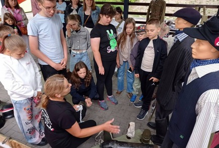 Żywa lekcja historii dla uczestników zajęć wakacyjnych w bibliotece.